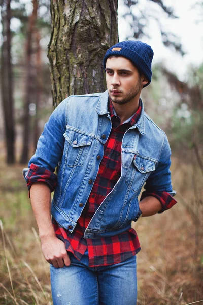 Man wearing jean jacket in forest