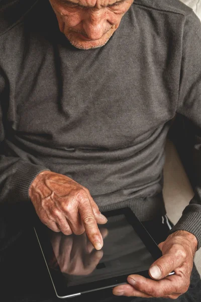 Senior holding a tablet in hands