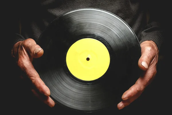 Vinyl record in the hands of old men