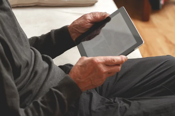 Senior holding a tablet in hands