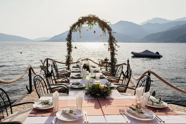 Destination wedding arch and banqouet covered table at sunset