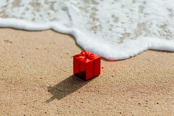 Gift red box on the beach