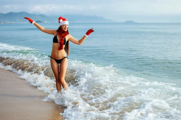 Santa girl making wish on the beach in tropics