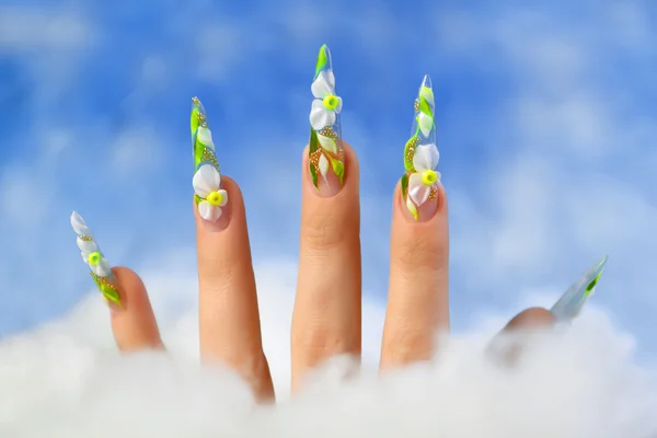 Acrylic flowers on women's nails.