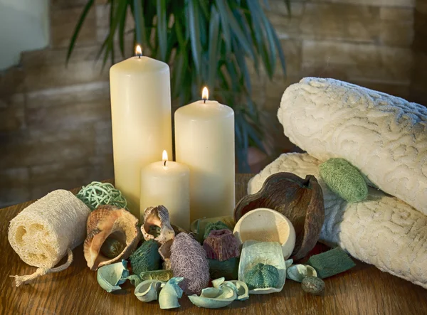 An arrangement of scented candles, at a spa, aromatic dried plant parts and towels Body