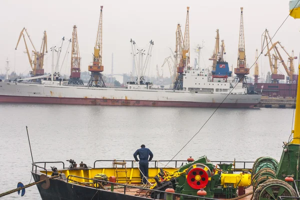 Sea port of Odessa. A crew member of one of the ships standing on the deck overlooking the port