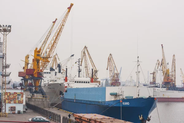 Commercial Port of Ilyichevsk. The loading of a cargo ship at dock in Odessa seaport. Mechanized metal work truck