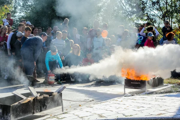 Teenagers show how to properly use a fire extinguisher