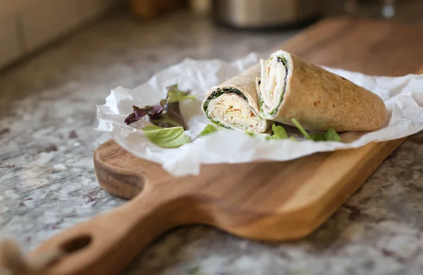 A healthy wrap with turkey, greens and cheese made with whole grain tortilla wrap