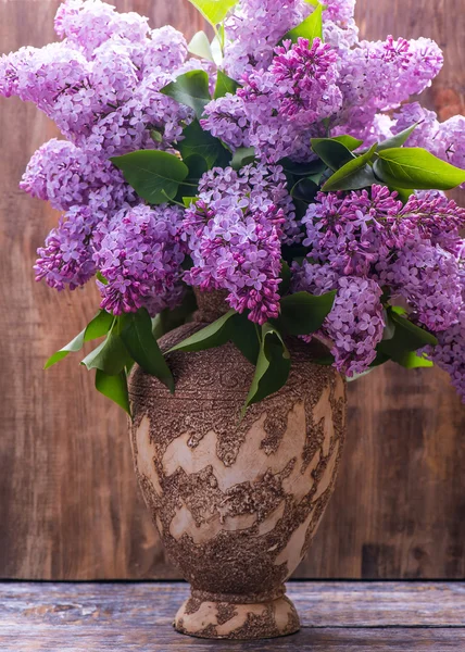 Lilac. Bouquet of lilac flowers in a ceramic vase on a wooden