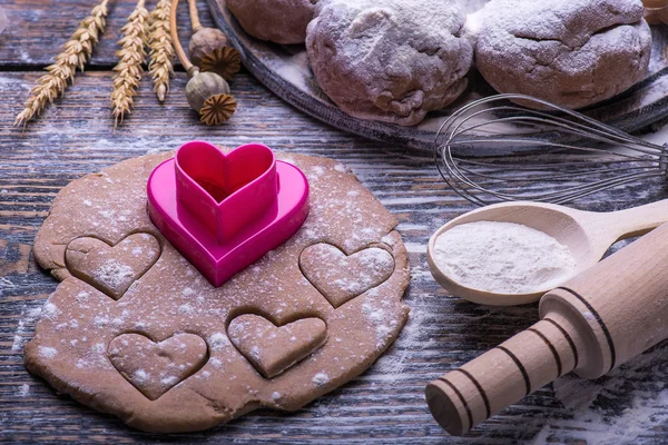 Cookies for Valentine\'s day. Ingredients for baking cookies, biscuits, flour, eggs, butter, baking dish in the form of heart on a wooden background.