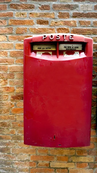 Red postal box public on brick wall