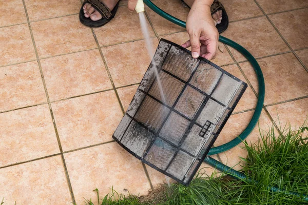 Cleaning dust filled air conditioning unit filters with with wat