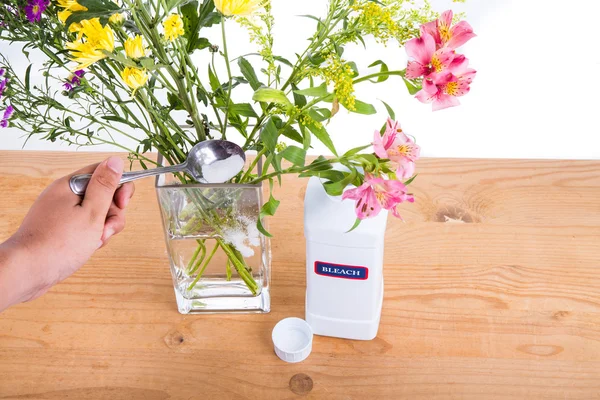 Add bleach powder into vase with water to keep flowers fresher