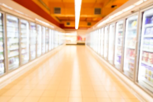 Defocused brightly lit frozen food aisle in modern supermarket