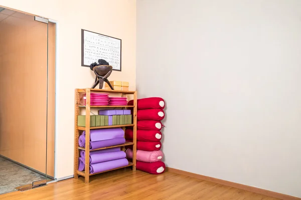 Yoga blocks, pillow, mats, pads, accessories stacked in yoga stu