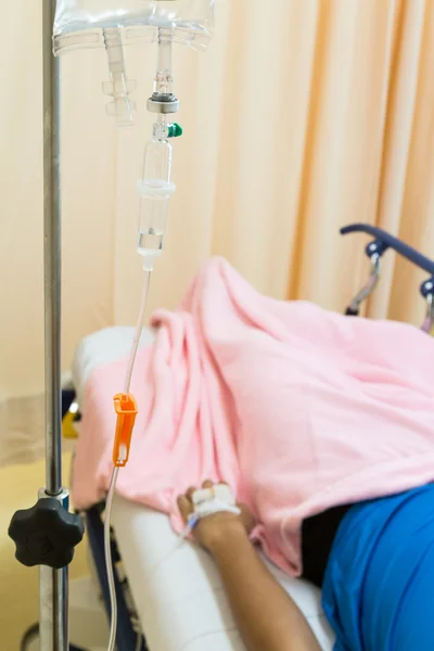 Focus on intravenous iv drips with patient in background