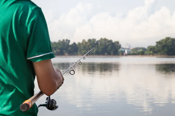 Man enjoying recreational fishing at a lake on a beautiful morning