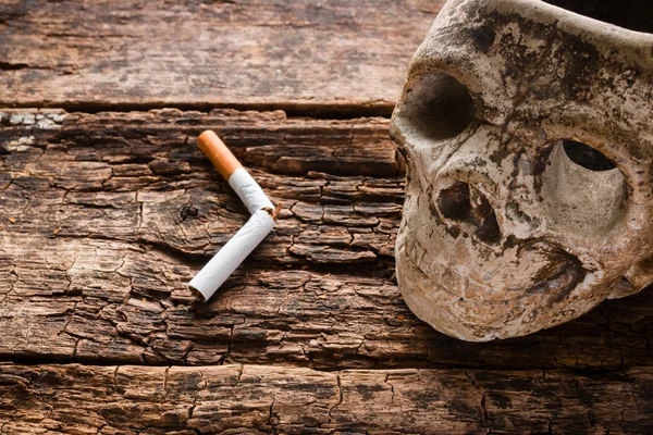 Broken cigarette and ashtray in the form of the skull - smoking kills concept