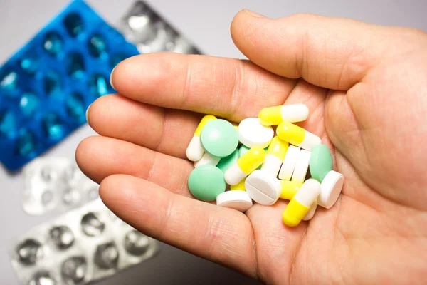 Medical pills in hand on white background