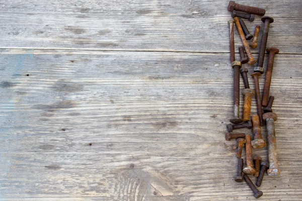 Old bolts or dirty bolts on wooden background, Machine equipment in industry work. Copy space to right.