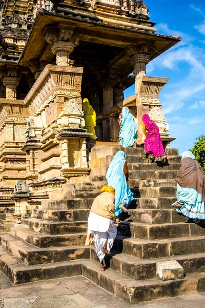 People in the national Indian clothes go up the stairs to the ancient temple