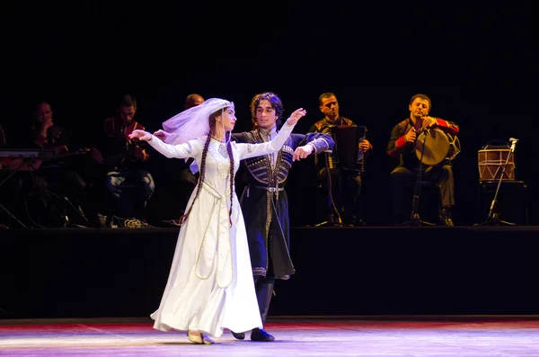 Man and woman dancing on stage wedding Georgian dance.