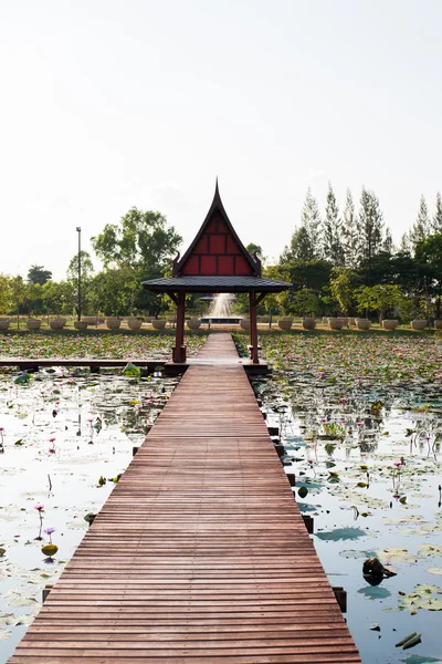 Thai wood lake pavilion cottage and wooden bridge around with lotus flower and green leaf