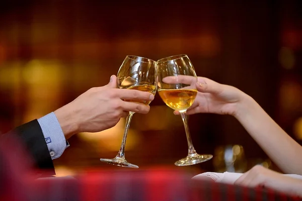 Cheers! Two hands with glasses of wine - stock photo
