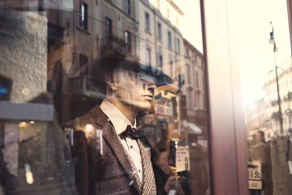 Well dressed Man behind a window watching people in the street