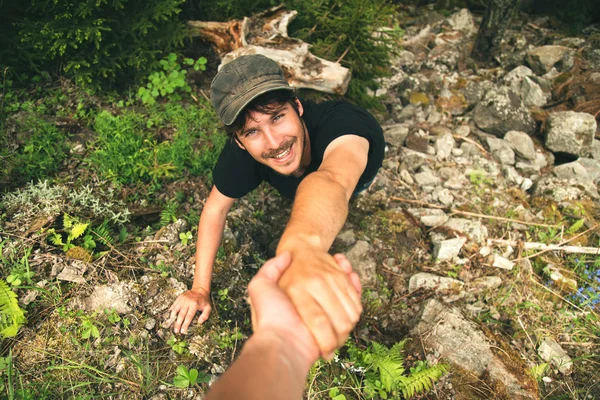 Climbers helping each other to climb the mountain