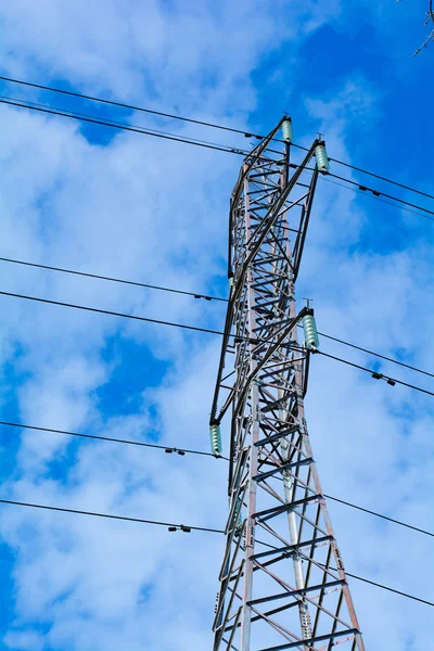 Power pole with high voltage against the blue sky