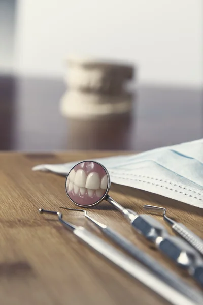 Dentists tools lying on a wooden desk