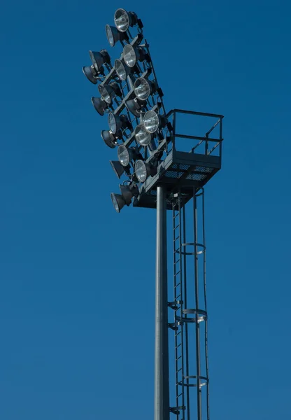 Floodlight. Stadium lighting against the blue sky. riflettore