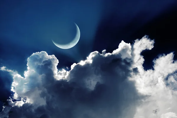 Crescent moon in a beautiful night sky with glowing clouds