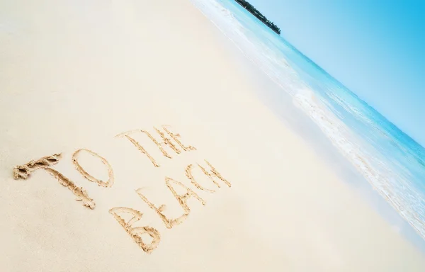 Beach with hand written text TO THE BEACH and sea on background