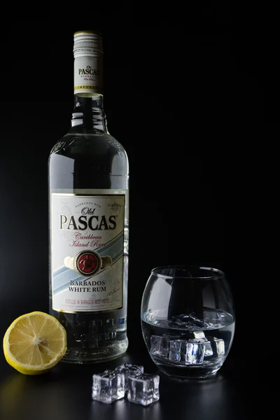 TIRASPOL, MOLDOVA - JUNE 5, 2016: Caribbean white rum bottles Old Pascas on a black background with a glass of ice and a Lemon.