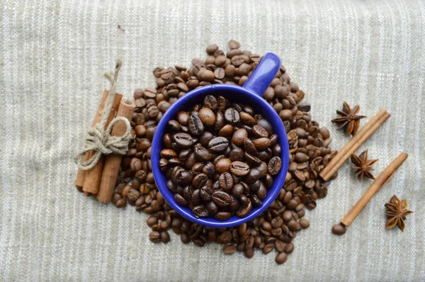 A hot Cup of coffee,coffee beans, Notepad, cinnamon, spices