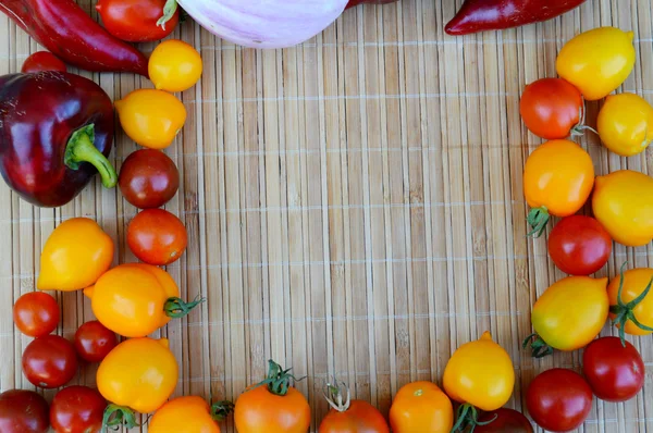 Vegetables, healthy food, small red and yellow tomatoes, red pepper, chili, eggplant on a wooden background