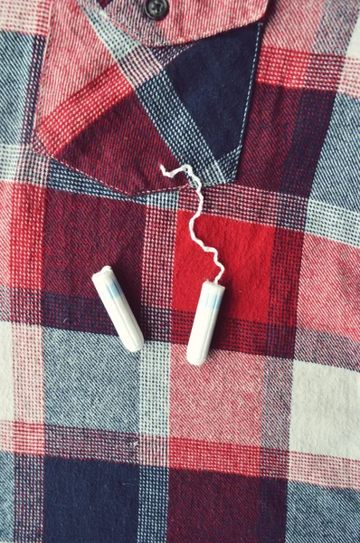 Woman hygiene protection, close-up.menstruation calendar with cotton tampons,orange Gerber,Sanitary pads on a red background