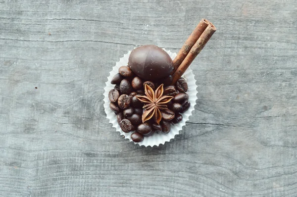 Bar of chocolate, coffee beans, hazelnuts, walnuts, cinnamon, coriander, spices .chocolate bar, candy bars,  different chocolate sweets on a wooden background.big choice of various sweets