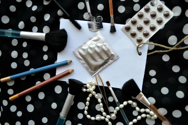 Set of female cosmetics on a white sheet of paper