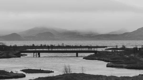 Abstract black and white landscape with old long bridge with mou