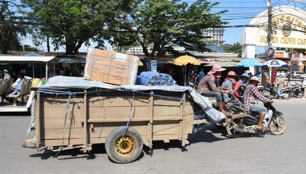 Workers transport goods by motorbike and cart in the Thai-Cambodian border town