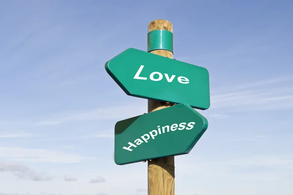 Wooden and metallic sign post with the words love and happines written on it