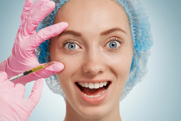 Reduction of wrinkles, injection, nasal labial folds. Portrait of a white woman during surgery filling facial wrinkles. Cosmetic is injected into facial skin cosmetics
