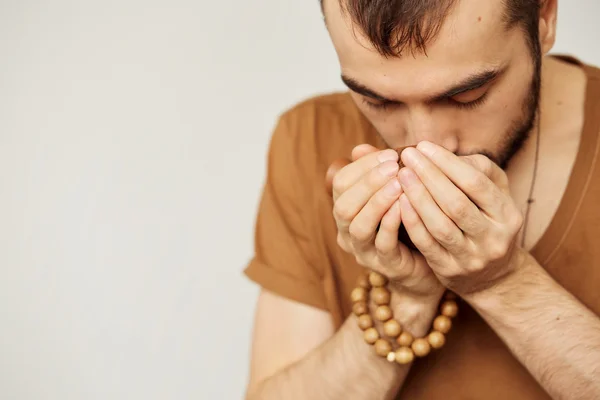 Young man sitting in meditation pose in front of tea set. Relaxation concept