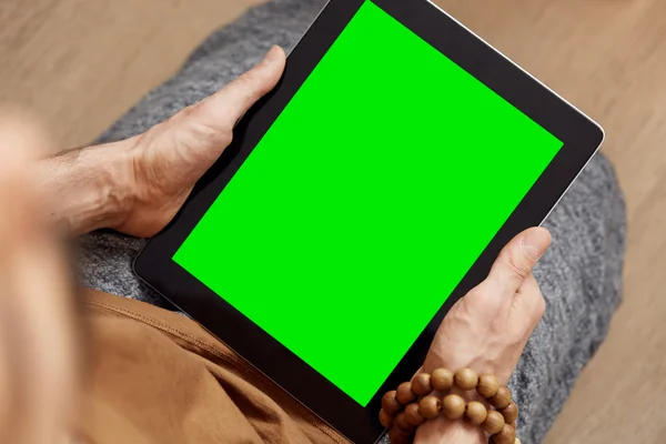 Man using digital tablet pc with green screen for internet and email. Adult man enjoys his digital tablet.