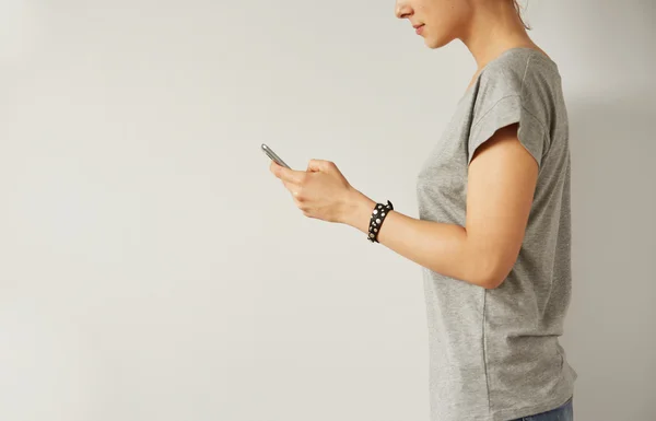 Closeup image of a teenager is searching information in network on mobile phone during free time. Young female student is revising photos on her cell telephone during break between lectures