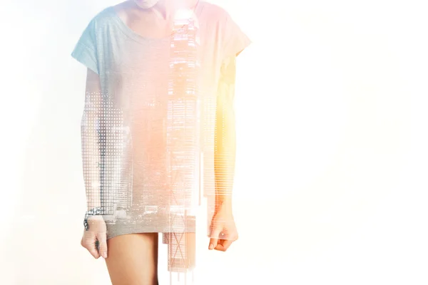Closeup photo of stylish girl wearing blank t-shirt and looking down. Double exposure, panoramic view contemporary megalopolis background. Space for your business message.
